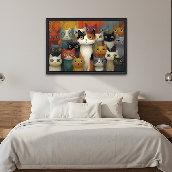 Black-framed colorful cats canvas wall art with a crowd of curious cats displayed above a bed with white pillows.