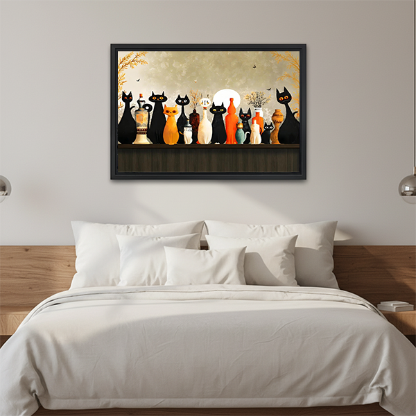Black-framed moonlit cats canvas wall art above a wooden console with folded blankets and a lantern.