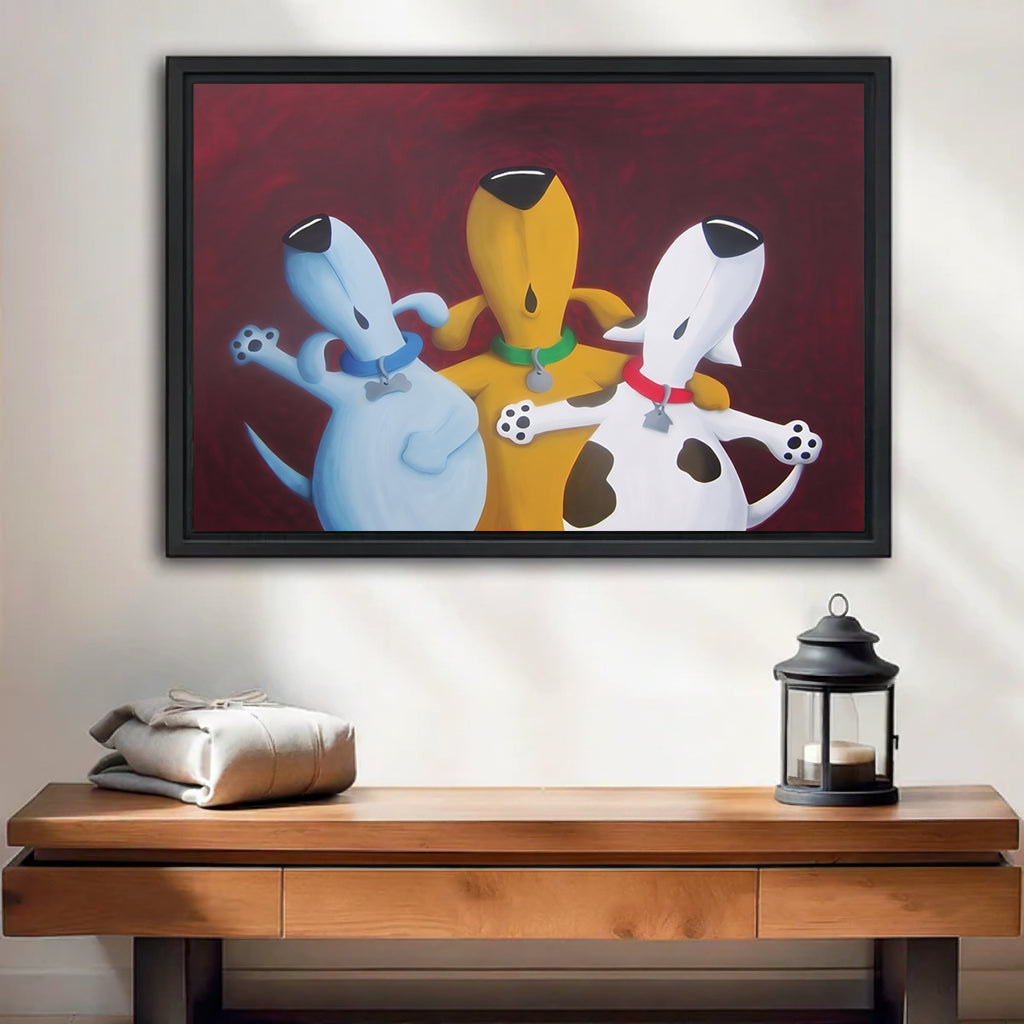 Whimsical three dogs framed wall art, blue yellow white dogs hugging on red background, black frame hung above wooden console table with lantern in minimalist entryway