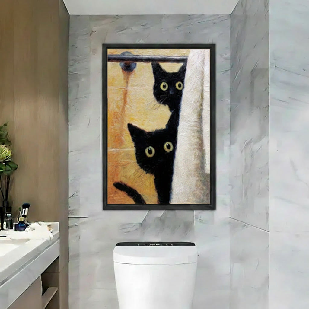Funny black cats peeking shower curtain framed canvas print, two golden-eyed black cats behind white curtain, black frame hung above toilet in grey marble bathroom