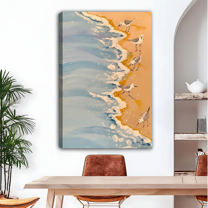 Sandpiper shorebirds on sandy beach with ocean waves canvas wall art, frameless gallery wrap, warm golden sand coastal oil painting style, hung above a light wood dining table with leather chairs in a bright modern dining room with indoor palm