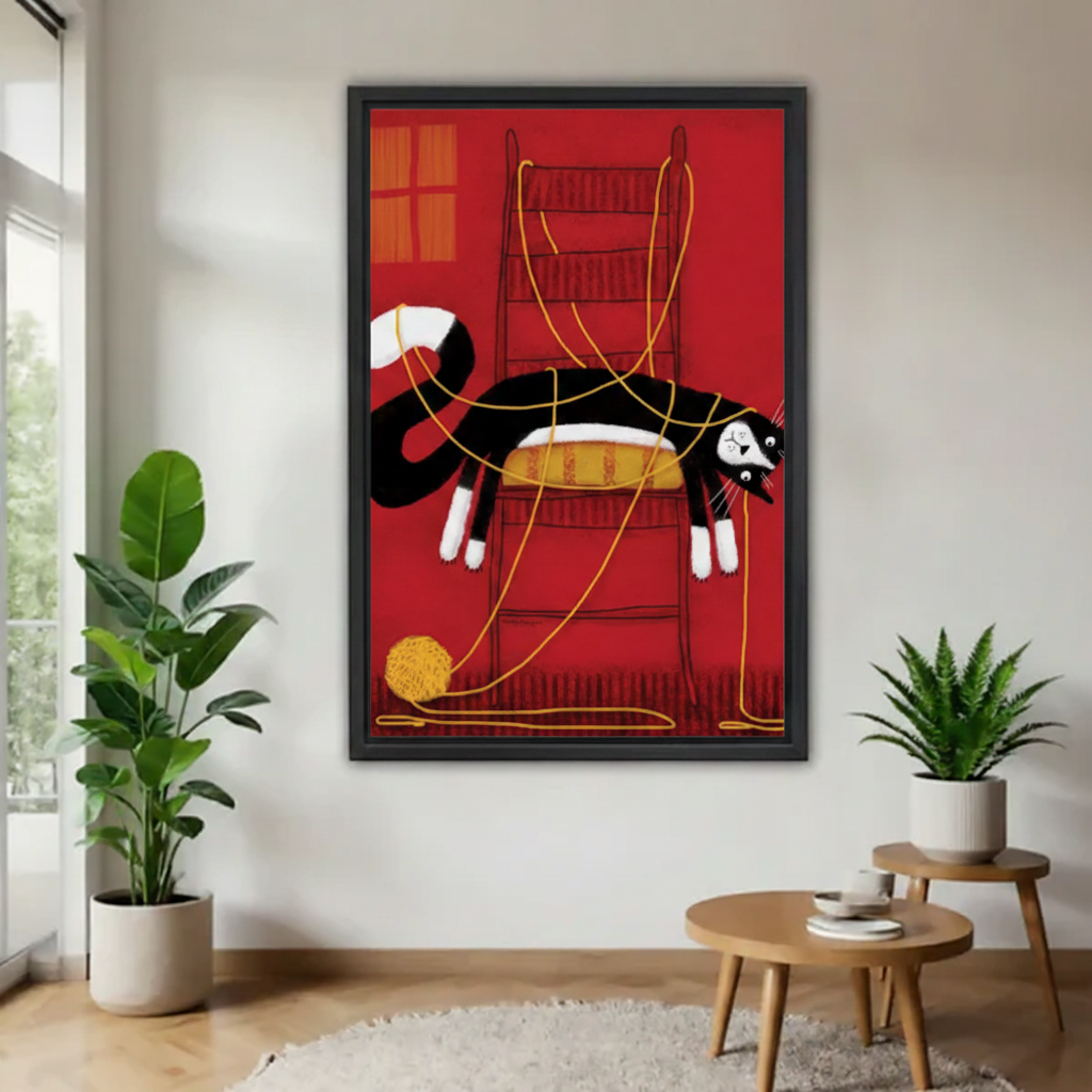 Tuxedo cat tangled in yarn whimsical framed canvas wall art — black and white cat draped over chair with golden threads, bold red background, black frame