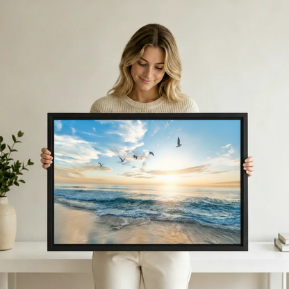 Ocean sunrise framed canvas wall art featuring blue sky and golden sunlight over calm beach waves