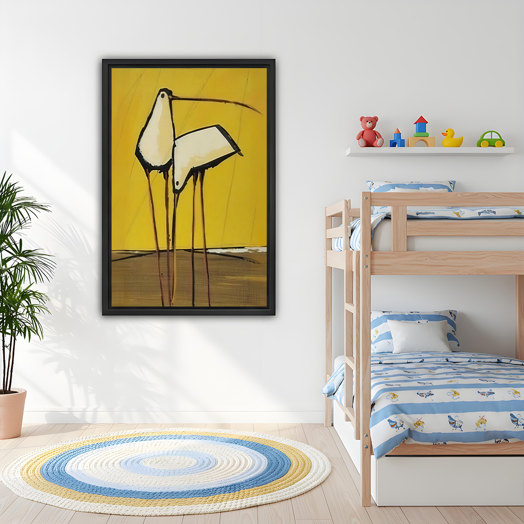 Woman holding black-framed abstract birds canvas wall art featuring two long-legged birds on a mustard yellow background.