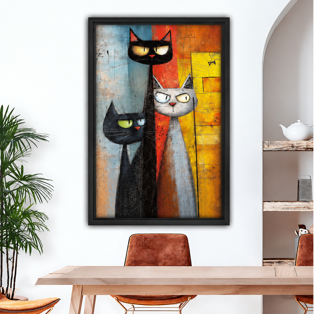 Black-framed abstract cat trio canvas wall art displayed above a wooden dining table with brown chairs.