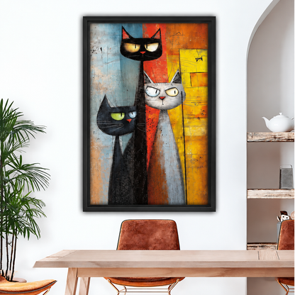Black-framed abstract cat trio canvas wall art displayed above a wooden dining table with brown chairs.