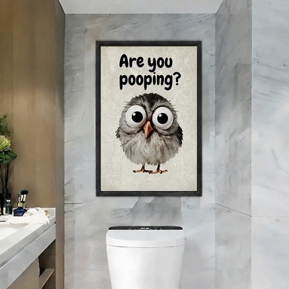Framed are you pooping owl canvas wall art hanging on a marble bathroom wall above the toilet.