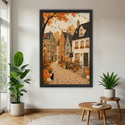  Framed autumn village and black cat canvas beside indoor plants.