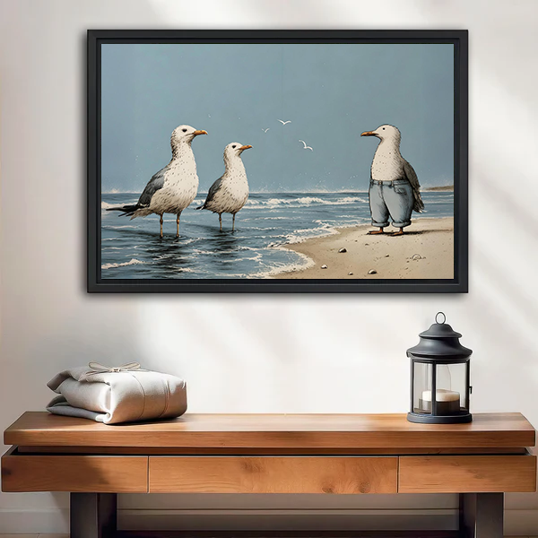 Whimsical beach seagulls canvas wall art in a black frame above a wooden console beside a lantern.