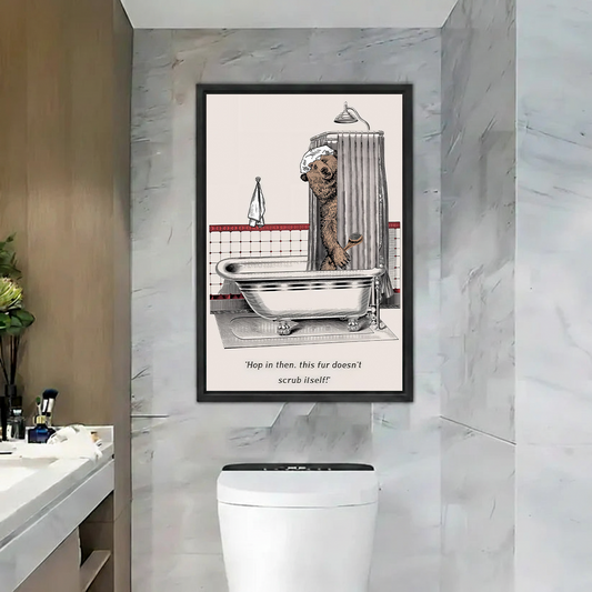 Black-framed bear bathtub wall art featuring a shower cap and scrub brush in a marble bathroom.