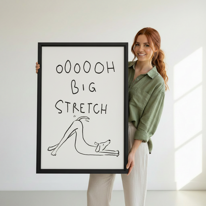 Smiling woman holding large framed funny dog big stretch line art print, showing print size reference against white background