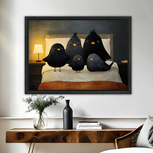 Framed whimsical black birds on a bed canvas wall art above a wood console with vase and flowers