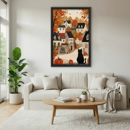 Black cat sitting in an autumn village with orange pumpkins and golden fall trees framed canvas above a cream linen sofa with round wood coffee table