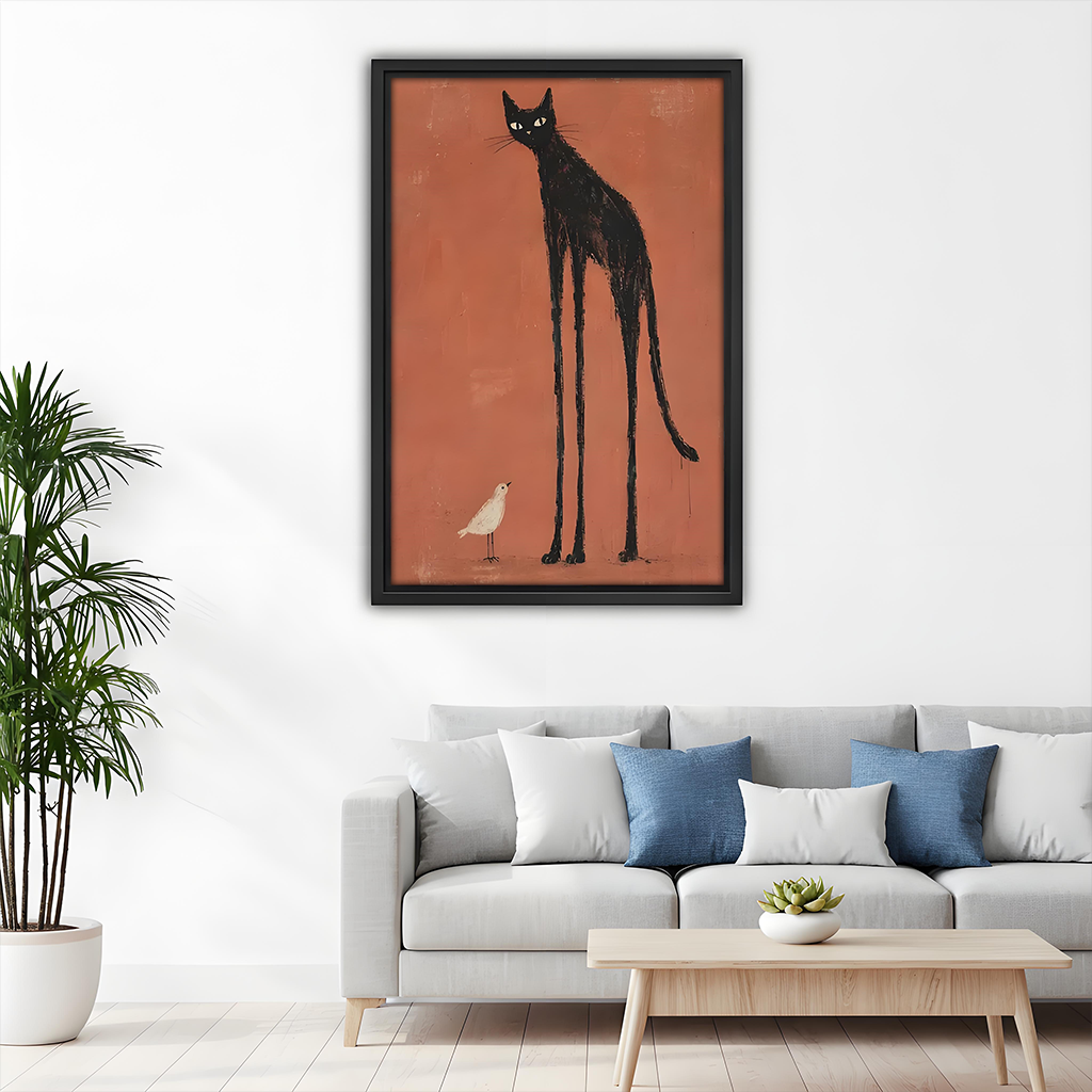 Framed black cat and bird canvas wall art with a tall black silhouette above a gray sofa with blue cushions.