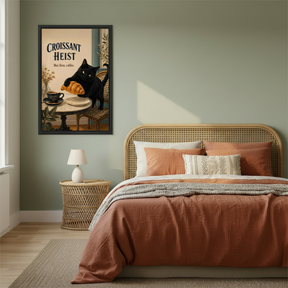 Woman holding framed black cat croissant canvas wall art featuring Croissant Heist lettering above a playful café scene.