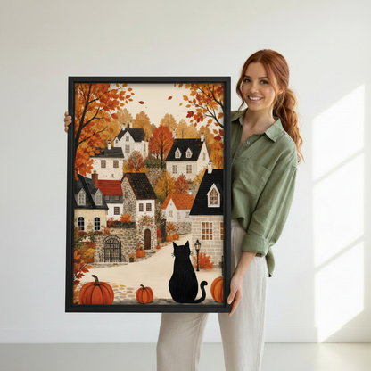 Woman holding large vertical framed canvas of a black cat watching an autumn stone village with pumpkins and orange fall foliage showing artwork size reference