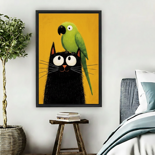 Large black framed pop-art style wall print of a fluffy black cat and green parrot against a mustard yellow background, hung on a bedroom wall beside a potted tree
