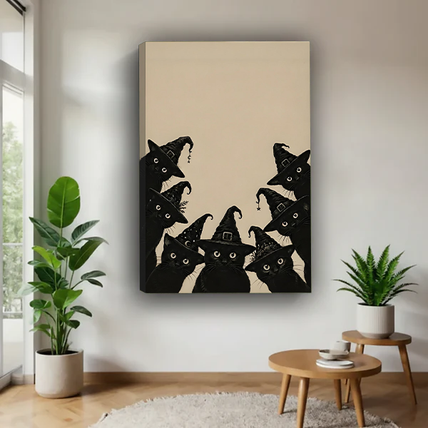 Black cat Halloween canvas wall art with witch hats displayed on a bright wall between leafy plants