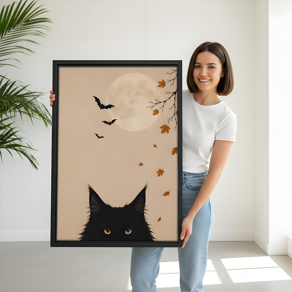 Framed black cat moon canvas wall art shows amber eyes beneath bats above a light sofa.