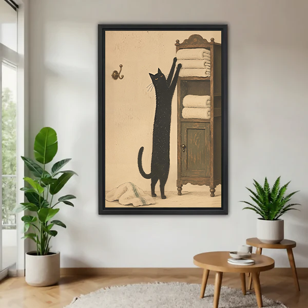 Black-framed black cat towel cabinet canvas wall art between green plants, showing a tall cat reaching for folded towels.