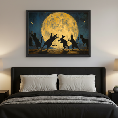 Black framed oil painting canvas of five black cat silhouettes dancing under a glowing golden full moon in a teal starry night sky, hung above a dark upholstered bed with white pillows and grey blanket with warm amber bedside lamps