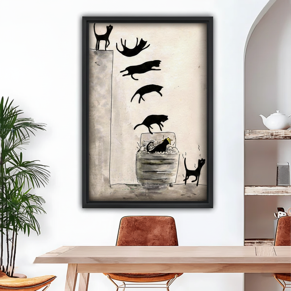 Black framed whimsical ink and watercolor canvas of multiple black cat silhouettes tumbling and diving in sequence from a high ledge into a trash can on a warm cream and grey textured background, hung above a wooden dining table with brown leather chairs