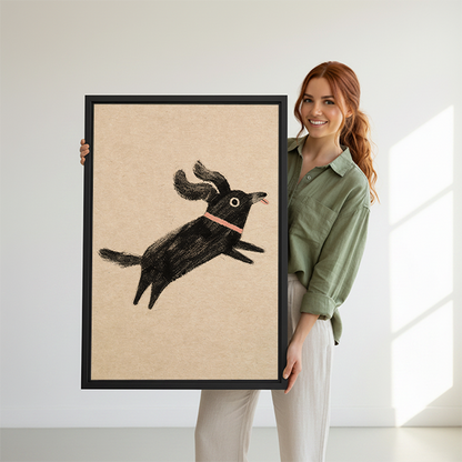 Woman holding large framed wall art print of a jumping black dog illustration with pink collar, showing size reference