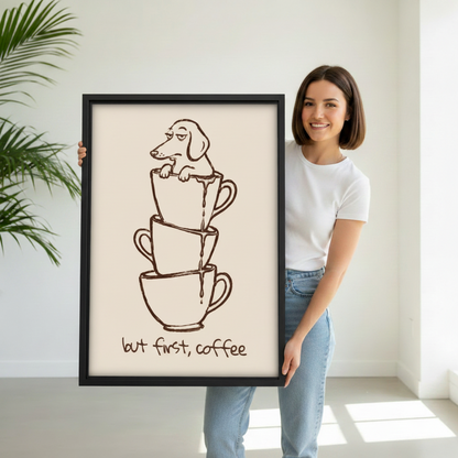 Woman holding a large black-framed line art print of a drowsy dachshund in stacked coffee cups with the But First Coffee quote