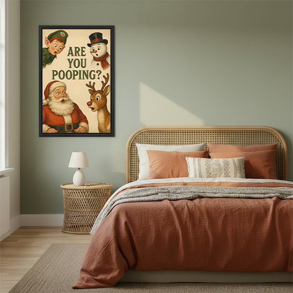 Framed Christmas bathroom canvas wall art featuring Are You Pooping lettering and festive characters above a cream sofa.