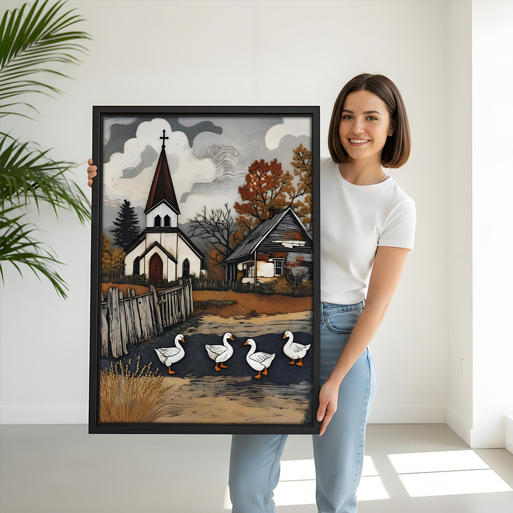 Framed church and geese canvas wall art with a rustic country lane above a gray sofa with blue cushions.