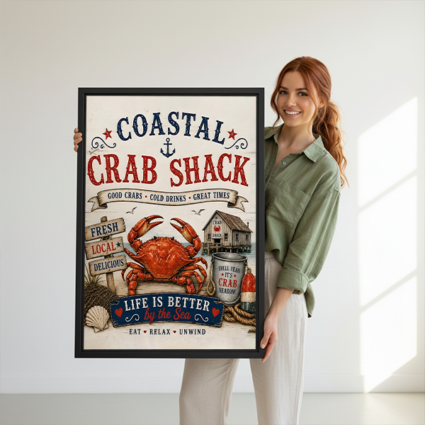 Woman holding black-framed coastal crab shack canvas wall art featuring a red crab, nautical lettering, and seaside details.