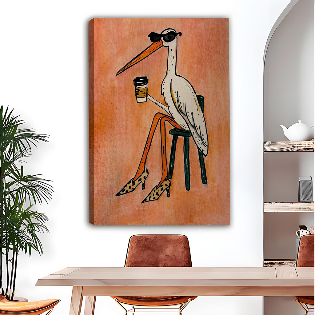 Black-framed coffee bird canvas wall art with a peach-orange background displayed above a dining table.