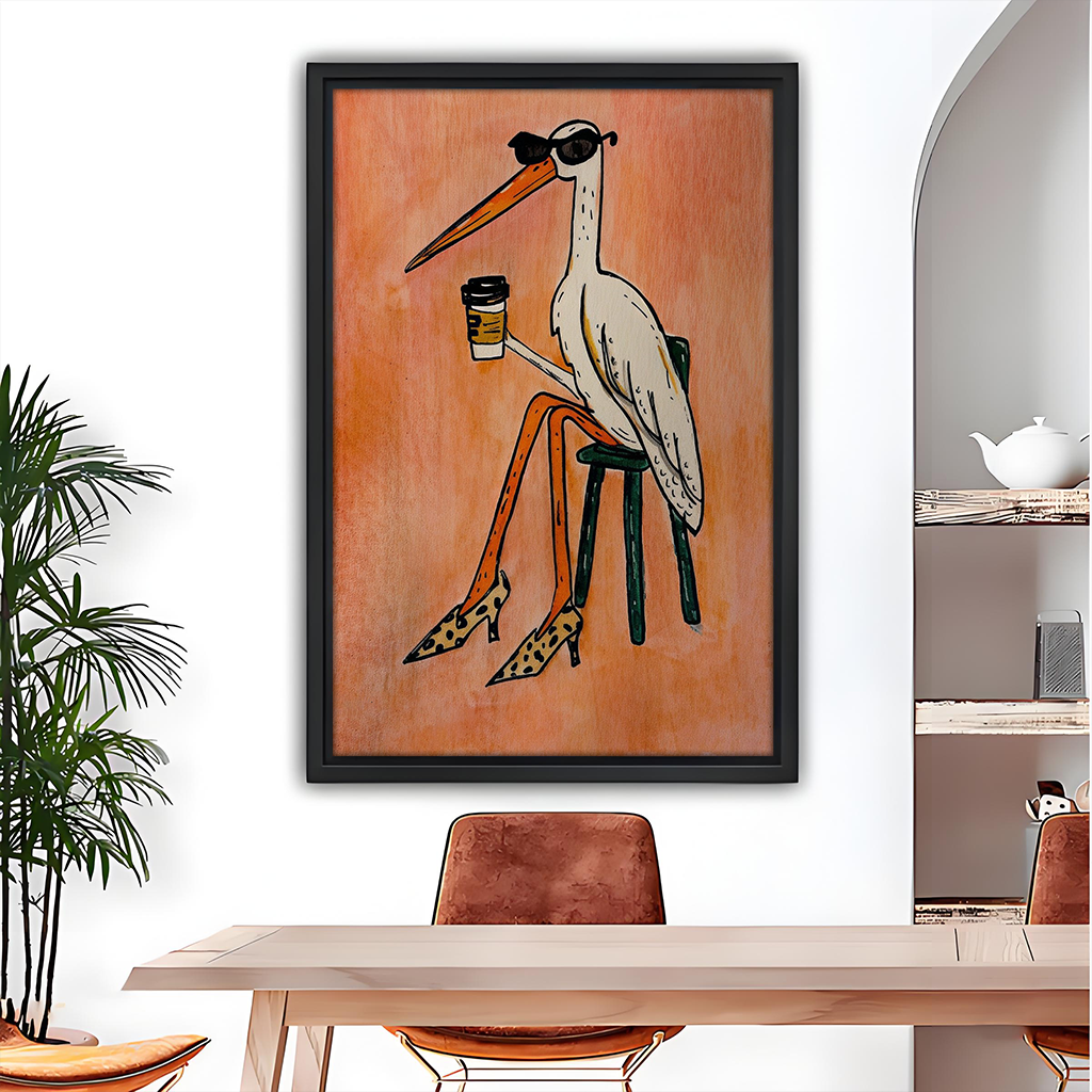 Coffee bird canvas wall art in a black frame above a gray sofa, featuring sunglasses and leopard-print heels.
