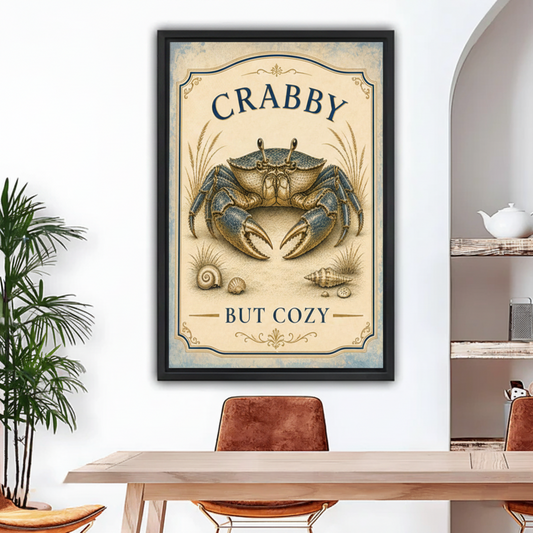 Black framed crabby but cozy coastal crab art print with ornate navy border, detailed blue crab illustration and scattered seashells on aged cream background, hung above a rustic dining table in a bright arched room