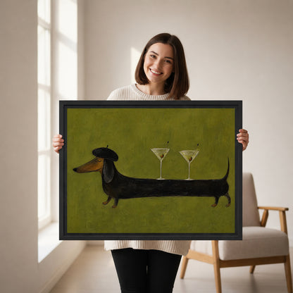 Woman holding framed dachshund martini canvas wall art featuring a beret-wearing dog balancing two cocktail glasses