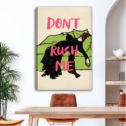 Frameless gallery wrap canvas of vintage-style woman in black dress draped over a green sofa with bold pink "Don't Rush Me" text on cream background above wood dining table with leather chairs