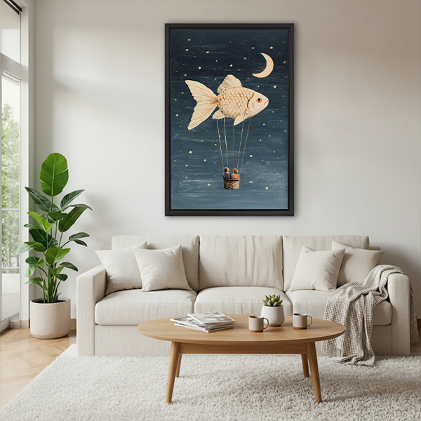 Woman holding black-framed fish balloon canvas wall art featuring two basket passengers below a fish and crescent moon.