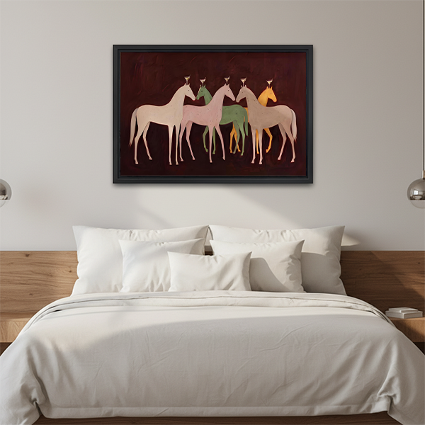 Black framed five horses canvas wall art displayed above a cream sofa with neutral cushions in a living room.