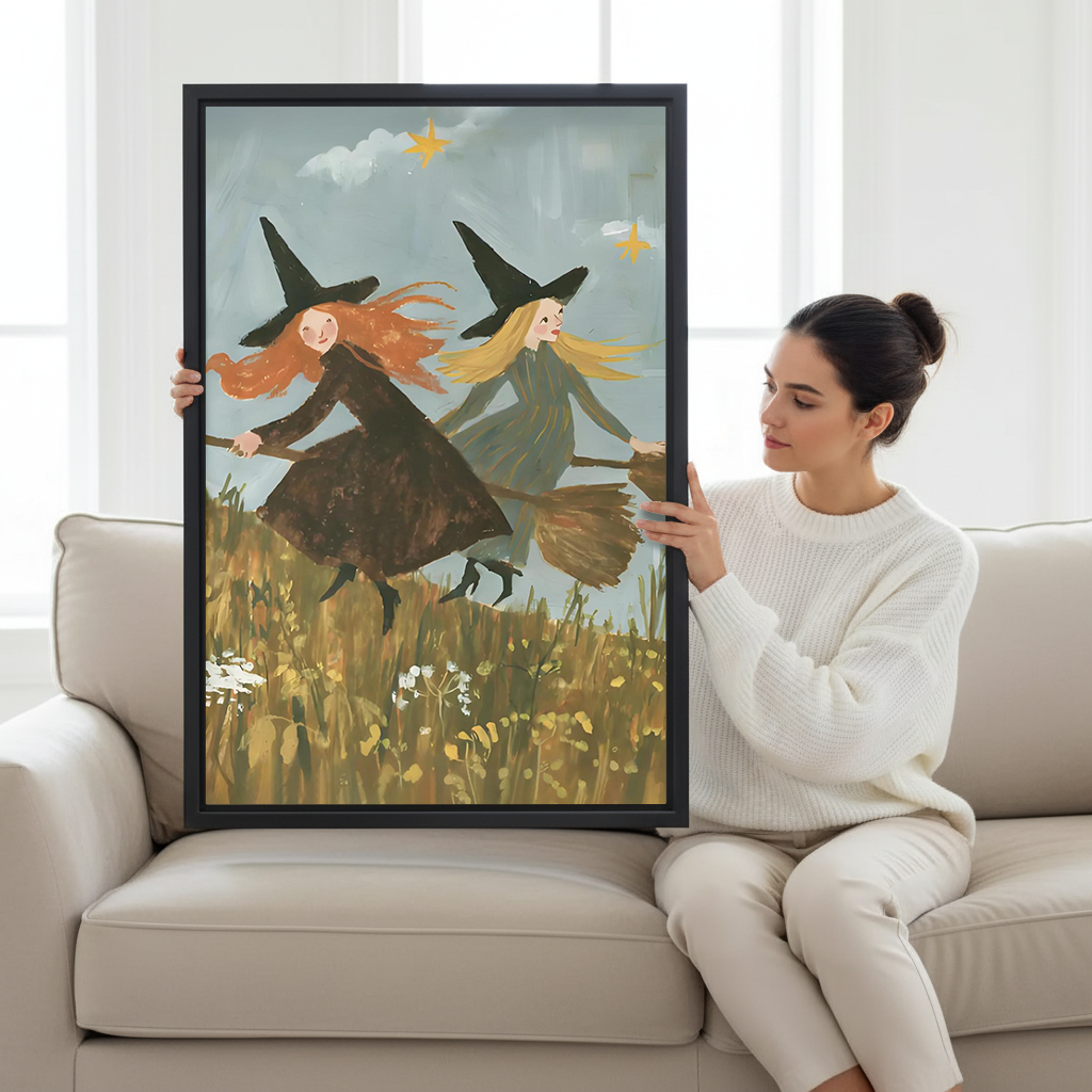 A woman holds flying witches canvas wall art with two witches, black hats, brooms, and a meadow below.