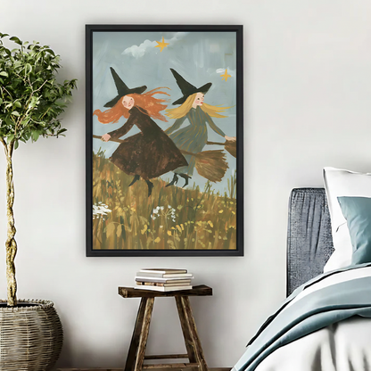 Flying witches canvas wall art above a wooden console, showing two witches on brooms over a wildflower field.