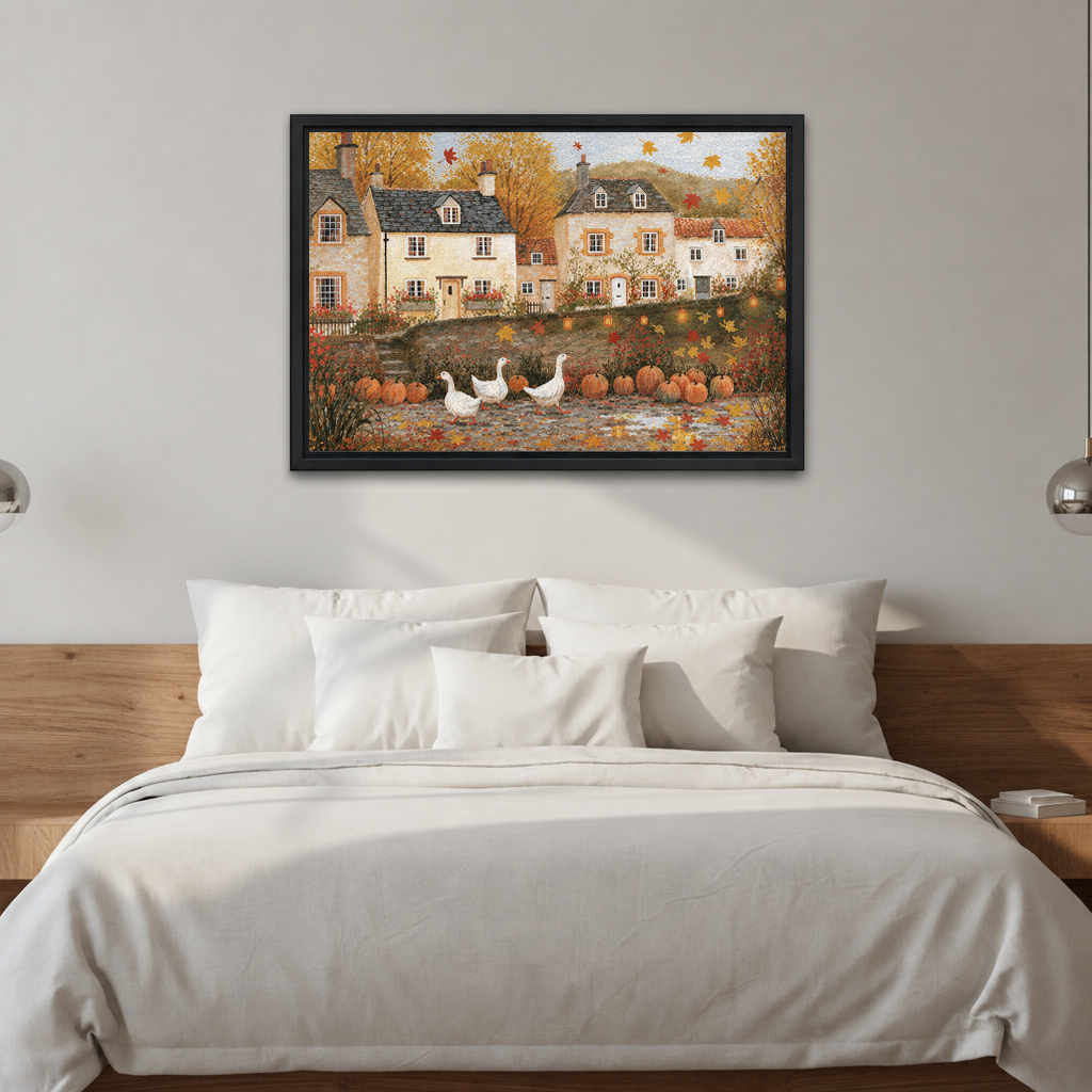 Black-framed folk art autumn village wall art above a bed with white bedding and a wooden headboard.