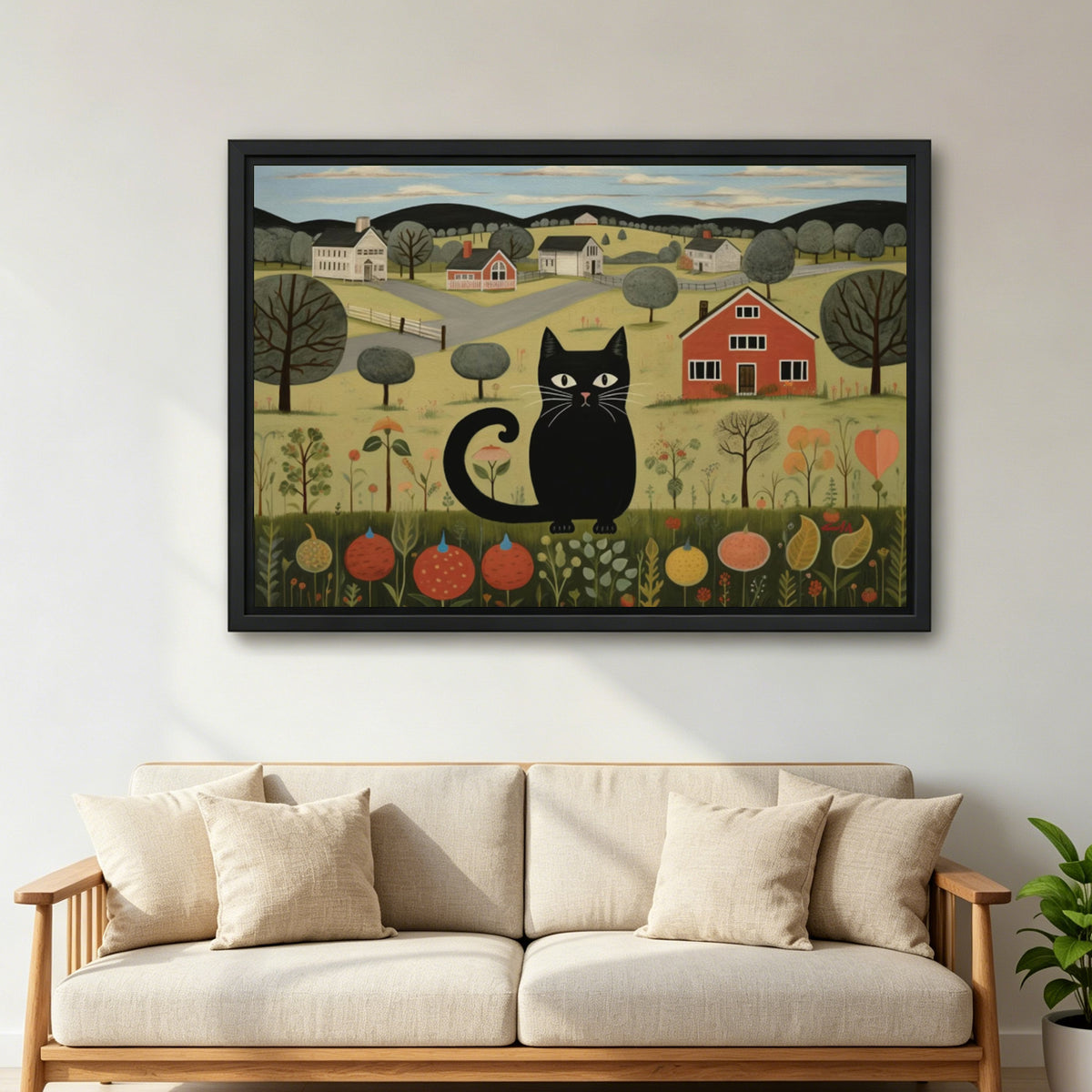 Large framed folk art black cat canvas wall art with a countryside scene above a cream sofa