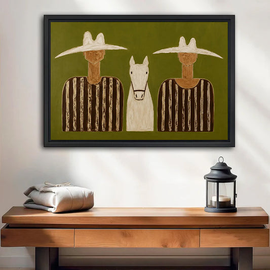 Folk art cowboy duo white horse striped shirt olive green black framed canvas wall art on white wall above rustic dark wood console table with linen bundle and iron lantern