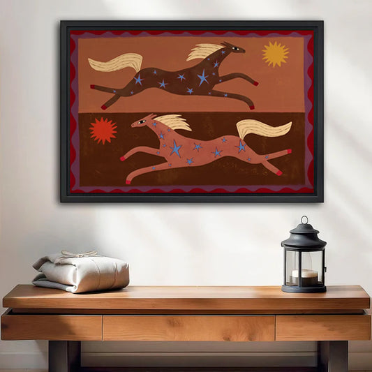 Folk art running horses blue stars gold mane red zigzag border sienna ochre black framed canvas wall art above rustic wood console table with linen bundle and iron lantern