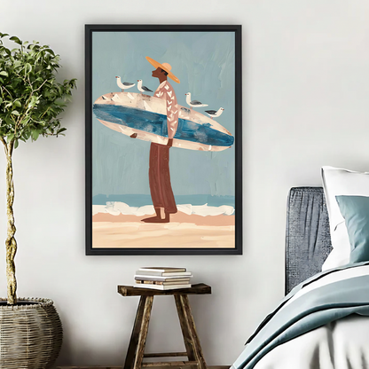 Folk art surfer with seagulls framed canvas wall art in black float frame above wooden stool in coastal bedroom, man in straw hat carrying blue surfboard on sandy beach