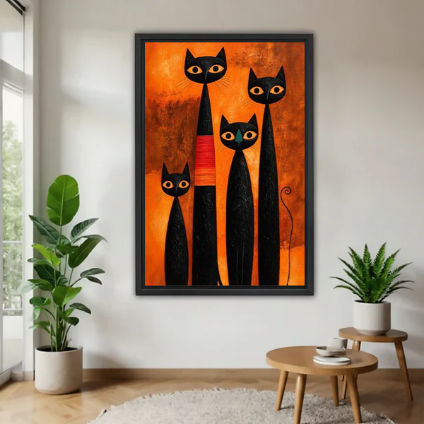 Black-framed four black cats canvas wall art with golden eyes and an orange background displayed above a cream sofa.