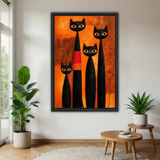 Black-framed four black cats canvas wall art with golden eyes and an orange background displayed above a cream sofa.
