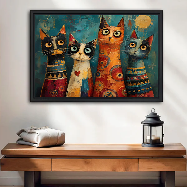 Whimsical four cats canvas wall art in a black frame above a wooden console and lantern.