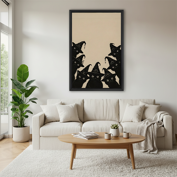 Framed black cat Halloween canvas wall art featuring witch hat cats above a cream sofa