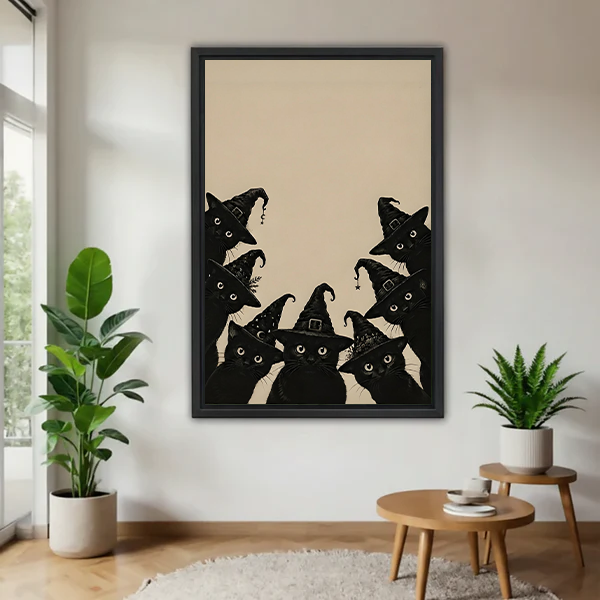 Woman holding framed black cat Halloween canvas wall art featuring witch hats in a bright room